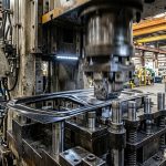 High-speed automotive press machine using precision stamping die components for metal sheet forming in industrial manufacturing facility.